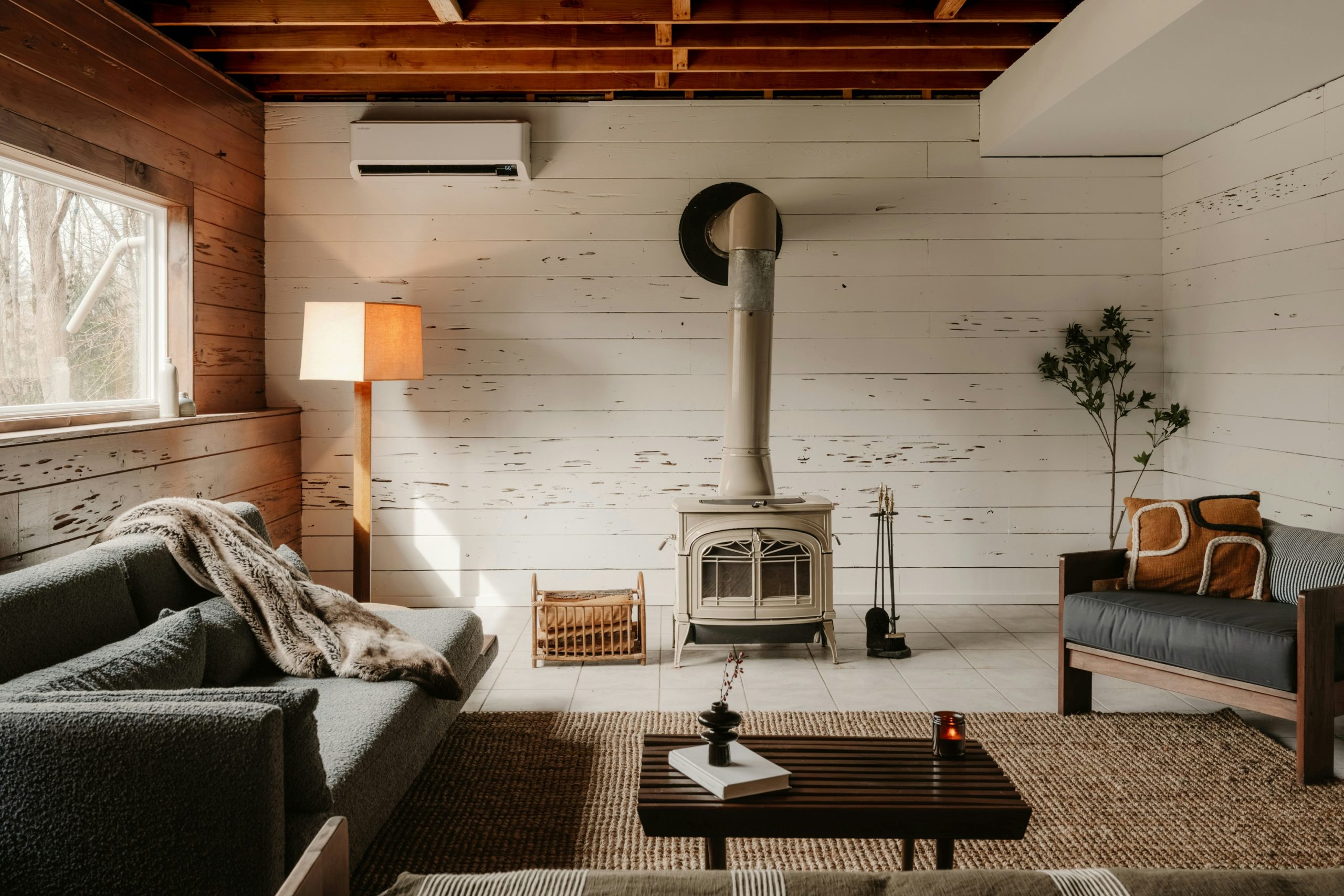 A cozy cottage living room warmed by a wood stove, ready for winter